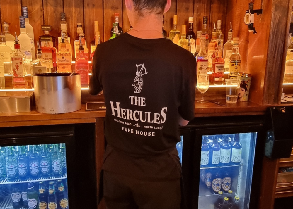 Staff member wearing The Hercules logo T-shirt, facing away!